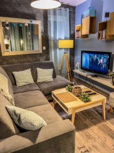 - un salon avec un canapé et une télévision dans l'établissement Apartment by Opieszyn, à Września
