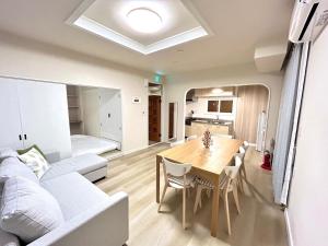 a living room with a table and a couch at わらしべハウス in Furano