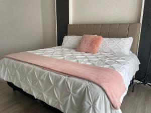 a bed with a pink blanket and pillows on it at Hotel Del Real in San Mateo Xoloc