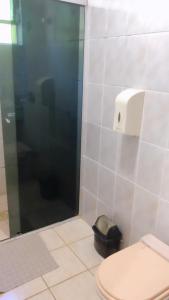a bathroom with a toilet and a glass shower at HOTEL VILLA QUATI CENTRO in Foz do Iguaçu