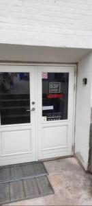 a pair of white doors with a sign on it at Cheap and very central basement apartment - Vindegade 53F in Odense