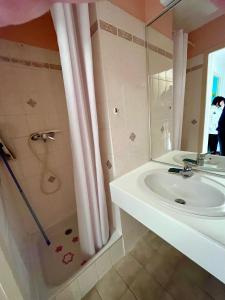 a white bathroom with a sink and a shower at Le 150 appartement au centre in Les Rousses
