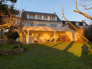 a large white house with a lawn in front of it at Villa Vieilles Vignes vue mer in Billiers