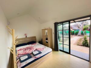 um quarto com uma cama e uma grande porta de vidro deslizante em Piyaporn Guesthouse em Khon Kaen