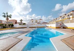 a swimming pool in a resort with blue water at Casa MACON RED in Caleta De Fuste