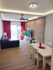 a living room with a couch and a table and chairs at Casa MACON RED in Caleta De Fuste