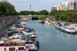 Um monte de barcos estão ancorados num rio. em Heart of Paris - Entire or Private Room Apartment - Bastille & Marais em Paris