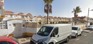 une camionnette blanche garée dans un parking avec voitures dans l'établissement Casa MACON RED, à Caleta de Fuste