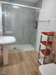 a shower with a glass door next to a sink and a toilet at Casa MACON RED in Caleta De Fuste
