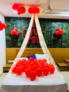 een hoop rode ballonnen op een bed met een bord bij HOTEL GLOBLE in Vadodara
