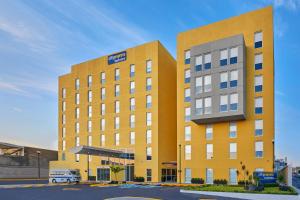 a yellow building with a van parked in front of it at City Express by Marriott Tepic in Tepic