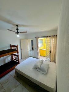 Hostel Encanto de Mongaguá في مونغاغوا: غرفة نوم بسرير ومروحة سقف