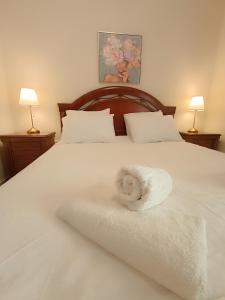 uma cama branca com uma toalha branca em villa panorama seaview em Tessalônica