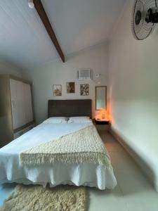1 dormitorio con 1 cama blanca grande en una habitación en Recanto Guarassol Apartamentos, en Sertão do Taquari