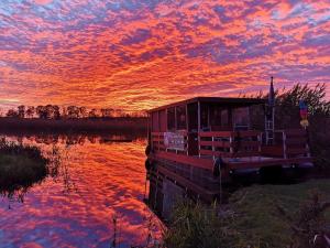 a boat sitting on the water with a sunset at Boot & Bike Hansestadt Anklam in Anklam