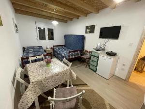 a living room with a table and a couch and a television at Apartment Marojevic Lipovo in Kolašin