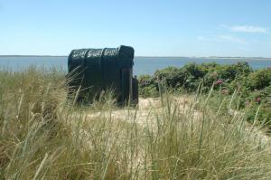 a black object in the middle of a field of grass at Haus Dorfschmiede, Whg Seestern in Alkersum +9 photos