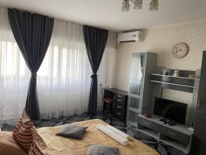 1 dormitorio con cama, TV y cortinas en Lucky Studio Mall Vitan en Bucarest
