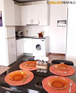 a kitchen with a table with plates on it at Blue Sky Montblanc - Swimming Pool & AC in Salou