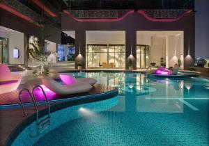een groot zwembad met paarse stoelen en een zwembad bij FHS Homestay @ Arte Plus Jalan Ampang T3-33A-07 in Kuala Lumpur