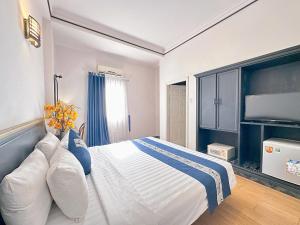 a bedroom with a large bed with blue and white pillows at New Star Inn Boutique Hotel-Near Bến Thành Market in Ho Chi Minh City +31 photos