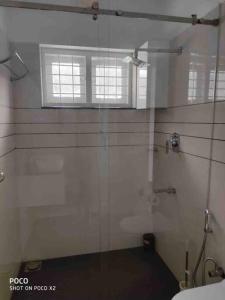 uma casa de banho com uma cabina de duche em vidro e um WC. em Ultra Modern Glass house with large Swimming pool and garden em Kottayam