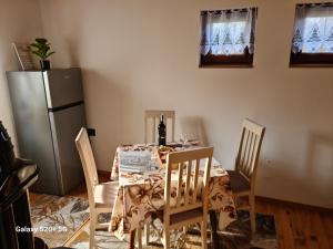 uma sala de jantar com uma mesa e um frigorífico em Vikendica "Šapat šume" em Bosansko Petrovo Selo