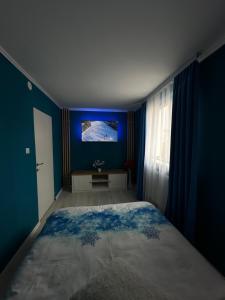 um quarto com paredes azuis e uma cama grande em Luxury Apartment em Topliţa