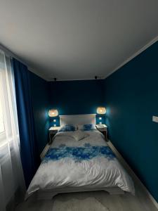 1 dormitorio con paredes azules y 1 cama grande en Luxury Apartment en Topliţa