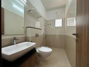 a bathroom with a sink and a toilet and a mirror at SRI KRISHNA RESIDENCY in Tiruchchirāppalli