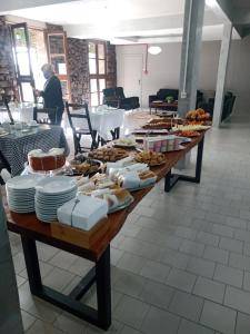 a long wooden table with plates of food on it at HOTEL CÁ DEI MONTI in Serafina Corêa