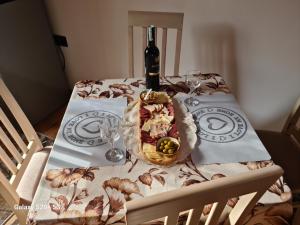 a table with a bottle of wine on top of it at Vikendica "Šapat šume" in Bosansko Petrovo Selo