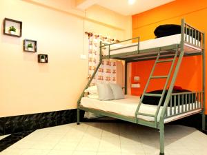 ダージリンにあるHidden Monkey Hostelsのオレンジ色の壁の客室の二段ベッド1台分です。