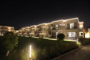 a building with lights on the side of it at night at Pyramids Park Resort Cairo in Cairo