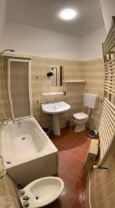 a bathroom with a tub and a toilet and a sink at Villa Kara in Lido degli Scacchi