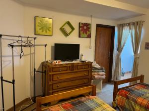 een slaapkamer met een dressoir met een televisie en een bed bij Casa da Avó Maria, Largo de Santo António, n 97395AL in Freixo de Espada à Cinta