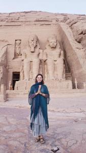 a woman standing in front of a monument at Mooody nobin haws in Abu Simbel