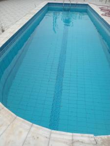 a swimming pool with blue tiles on the ground at شالية ألأمراء 