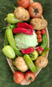 a wooden bowl filled with vegetables on a table at Eco Village Jasavić II in Plav