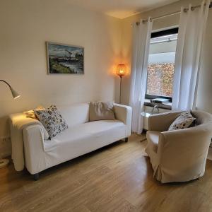 - un salon avec un canapé blanc et une chaise dans l'établissement Ferienwohnung Worpswede-in-Sicht, à Lilienthal