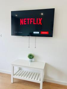 a white table with a tv on a wall at Appartement centre historique in Mulhouse