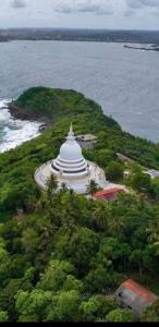 a large white building on a island in the ocean at RM Holiday Home in Hikkaduwa