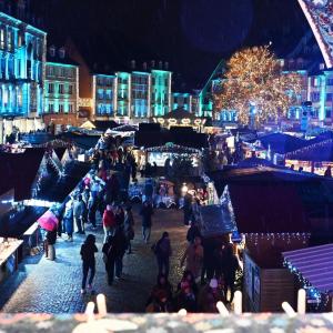 a crowd of people walking through a christmas market at night at Appartement centre historique in Mulhouse