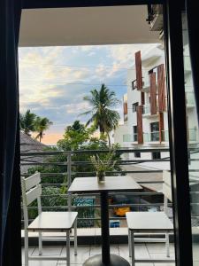 a table and chairs on a balcony with a view at Hôtel Grand Bay in Nosy Be