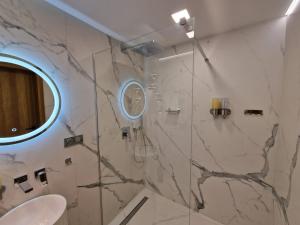 a bathroom with a marble shower with a mirror at Apartamenty Sebastiana in Kraków +141 photos