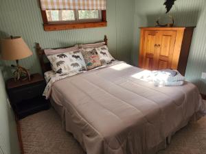 ein Schlafzimmer mit einem großen Bett in einem Zimmer in der Unterkunft The White Conifer Cabin 