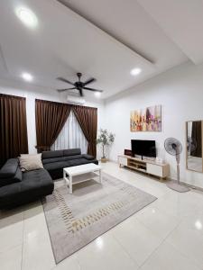 a living room with a black couch and a tv at 4 bedrooms house with Private Pool ! in Kota Bharu