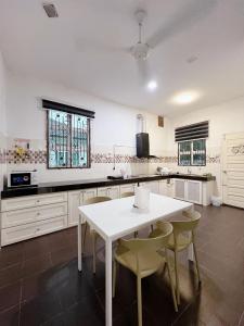 a kitchen with a white table and chairs at 4 bedrooms house with Private Pool ! in Kota Bharu