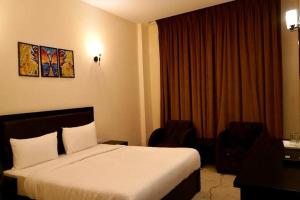 una camera d'albergo con letto e scrivania di Hotel Saluja Primeland a Parāsia