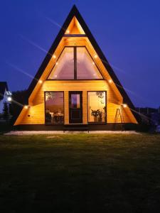 uma casa com um telhado triangular à noite em Domki Żabiniec em Jedle